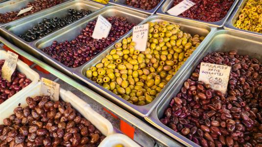 Verschiedene Olivensorten in großen offenen Bottichen auf einem griechischen Markt