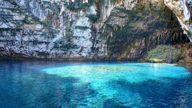 Zur Mittagszeit scheint die Sonne durch ein Loch in der Decke des Melissani Sees auf der Insel Kefalonia griechenland urlaub, geheimtipps griechenland, melissani see, kefalonia